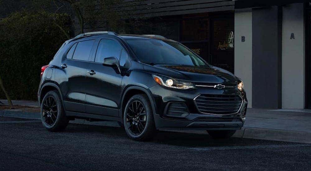 A black 2021 Chevy Trax is shown parked near a curb.