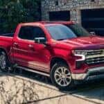 A red 2024 Chevy Silverado 1500 RST is shown parked near a building.