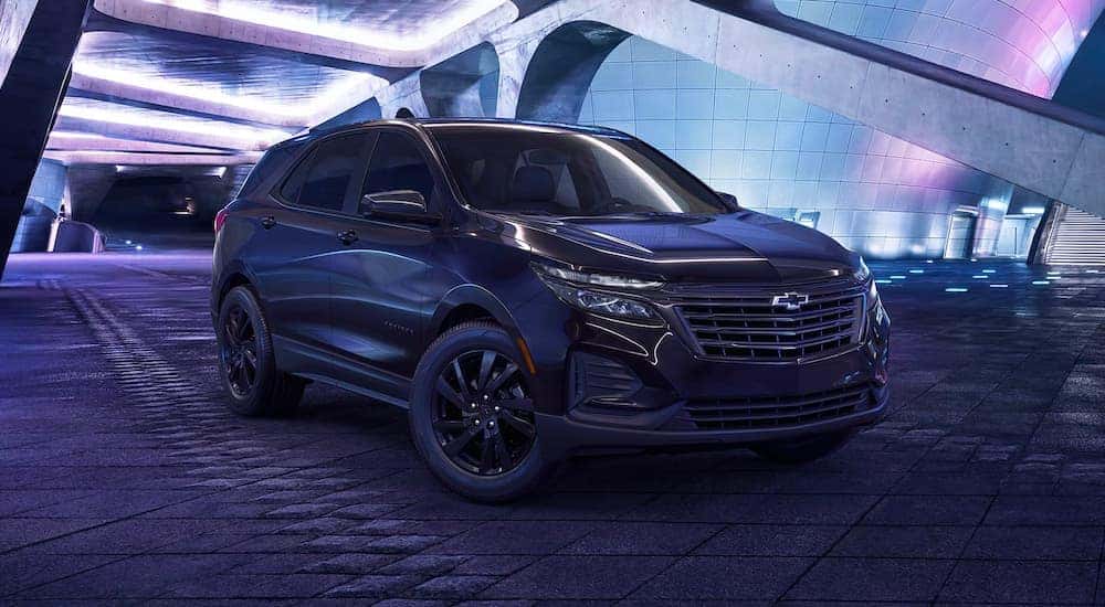 A black 2023 Chevy Equinox Midnight Edition parked in moody lighting.