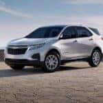 A white 2024 Chevy Equinox LS parked under an open sky.