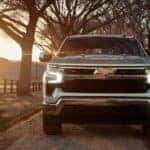 A silver 2024 Chevy Silverado 1500 LT is shown from the front while driving.