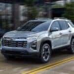 A silver 2025 Chevy Equinox is shown driving from a Chevy dealer near Hudson..
