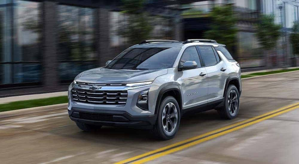A silver 2025 Chevy Equinox is shown driving from a Chevy dealer near Hudson.