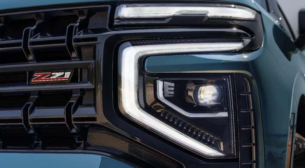 A close-up of a headlight on a green 2025 Chevy Tahoe Z71 is shown.