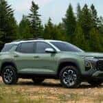 A green 2025 Chevy Equinox is shown parked off-road.
