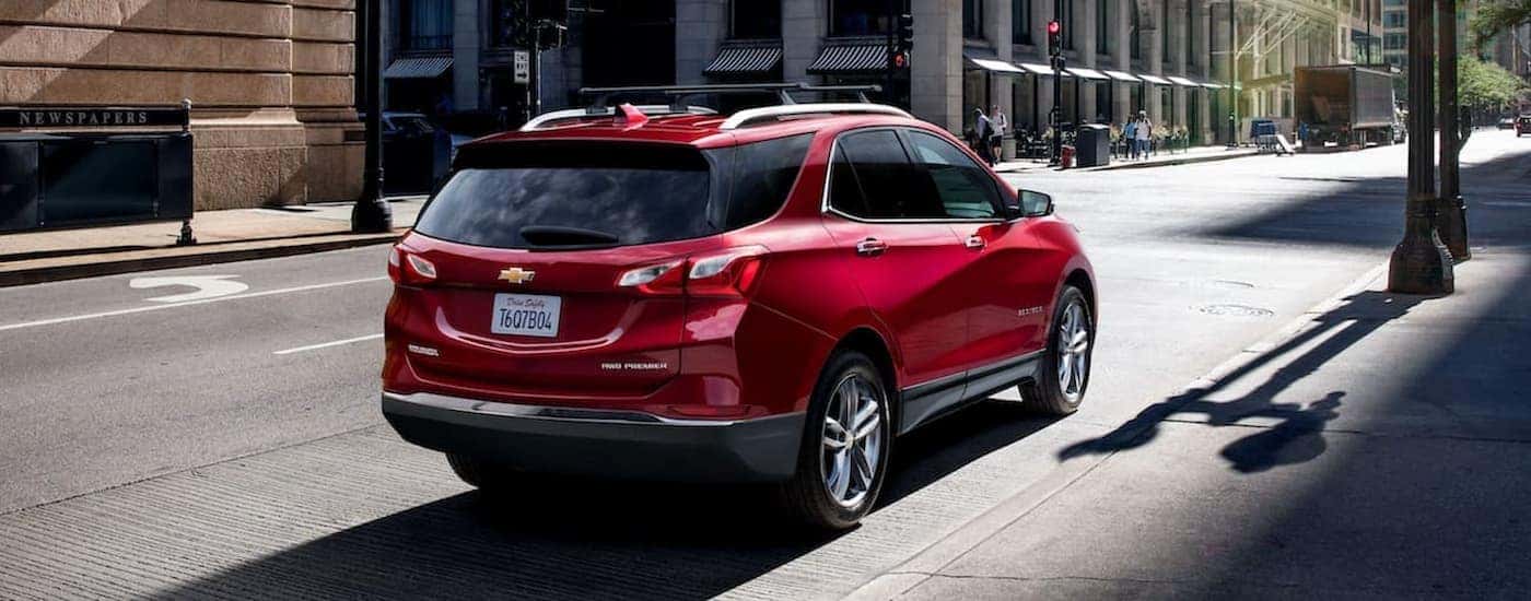 A red 2021 Chevy Equinox Premier parked on a city street.