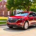 A red 2018 Chevy Equinox is shown driving.