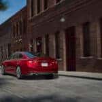 A red 2024 Chevy Malibu RS is shown from the rear at an angle.
