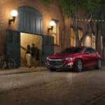 A red 2021 Chevy Malibu RS is shown from the front at an angle on a city street.