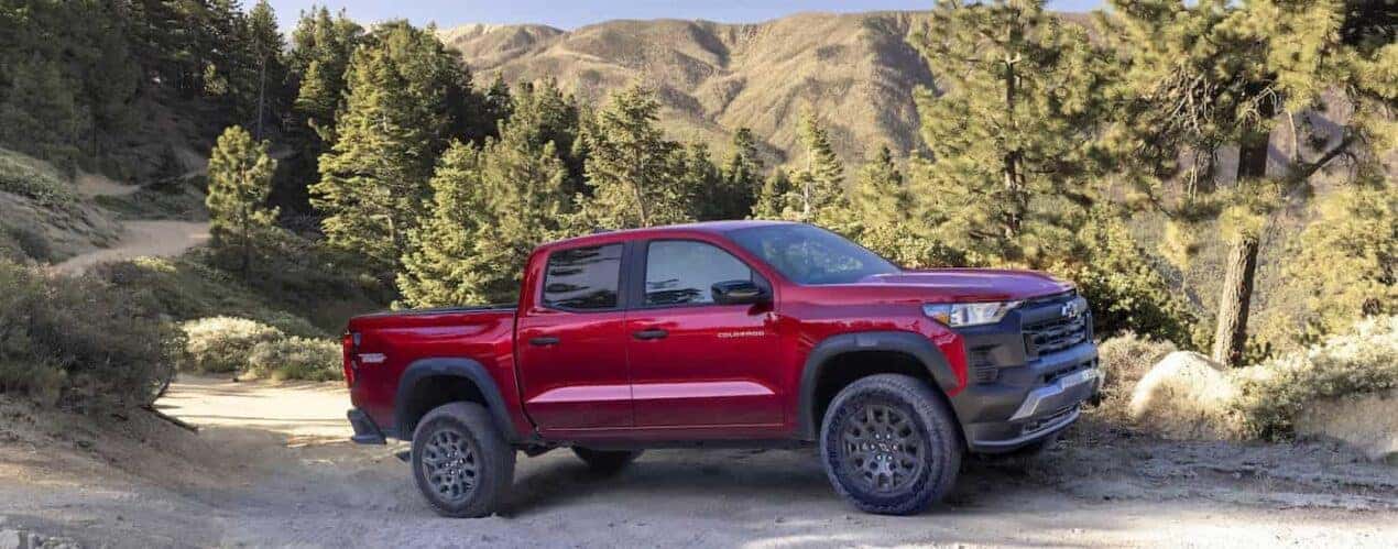 A red 2023 Chevy Colorado Trail Boss is shown from the side while off-road.