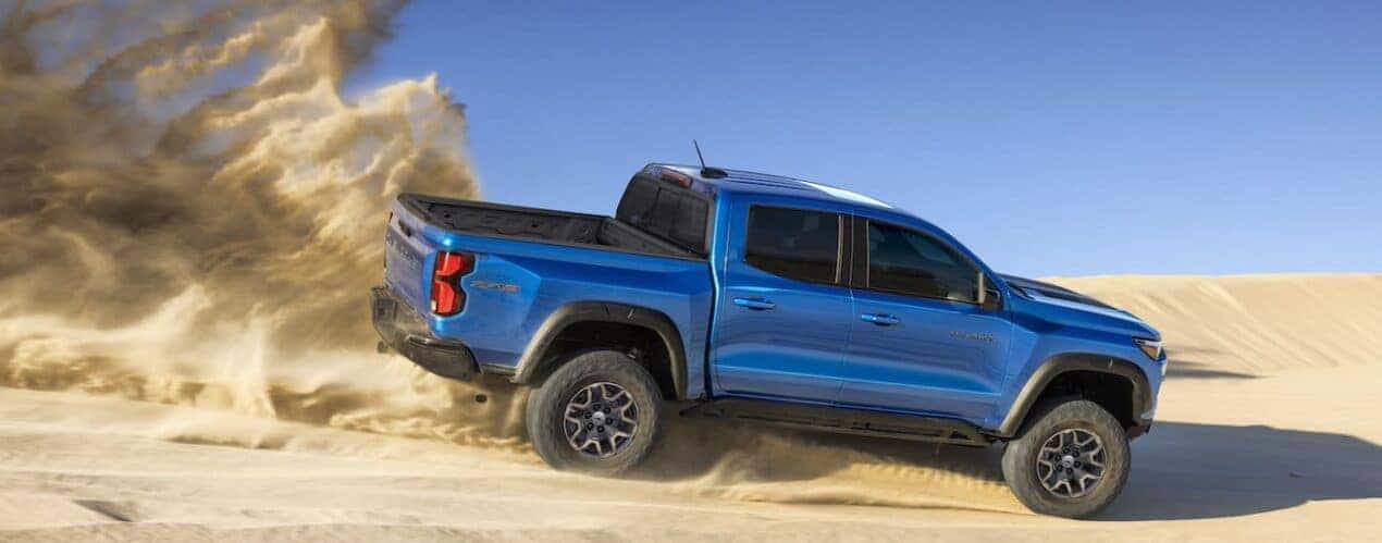 A blue 2024 Chevy Colorado ZR2 is shown from the side while off-road.