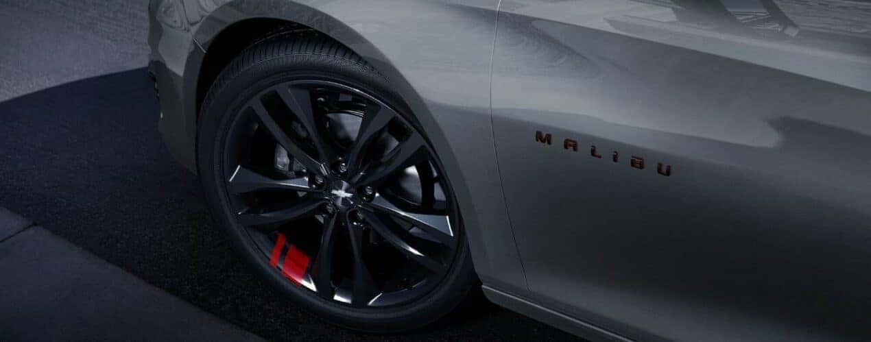 A close-up on the wheel of a silver 2024 Chevy Malibu Redline.