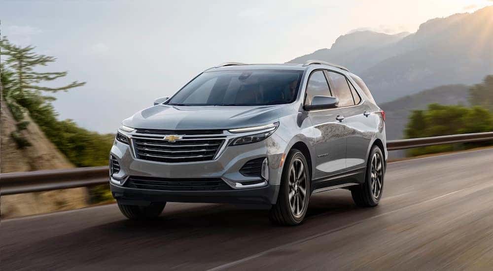 A white 2024 Chevy Equinox driving from a Chevy dealer near Colonie.