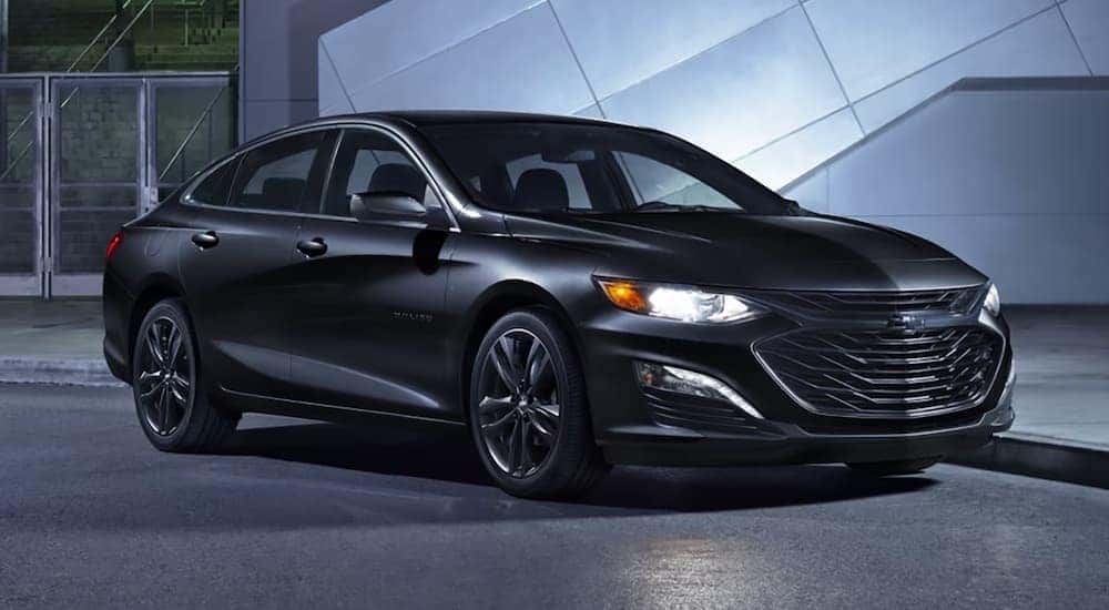 A black 2024 Chevy Malibu Midnight parked in a building.
