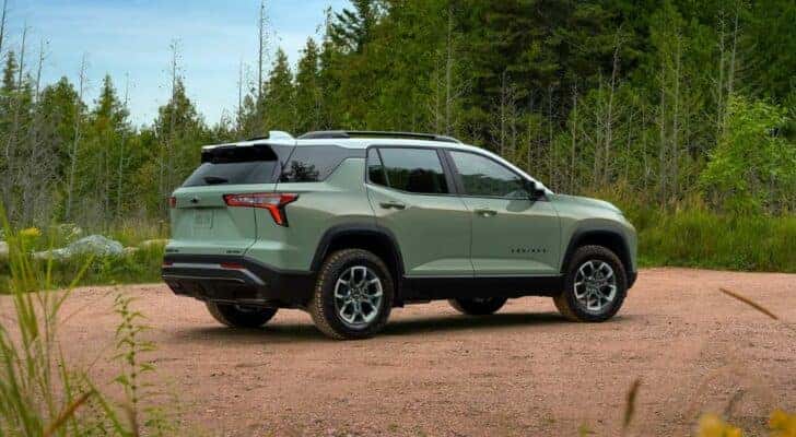 A green 2025 Chevy Equinox Activ is shown near trees after visiting a Chevy dealer near Colonie.