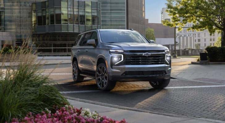A silver 2025 Chevy Tahoe RST driving through the city.