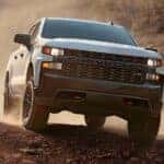 A white 2020 Chevy Silverado 1500 Trailboss Z71 kicking up dust while off-roading.
