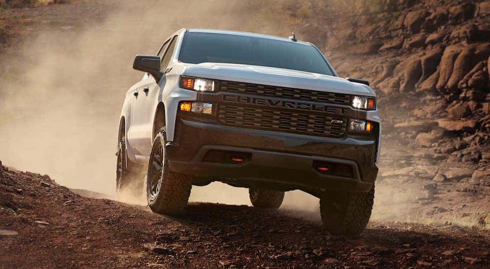 A white 2020 Chevy Silverado 1500 Trailboss Z71 kicking up dust while off-roading.