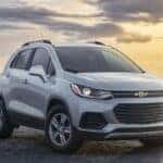 A silver 2021 Chevy Trax for sale is shown parked near an ocean.