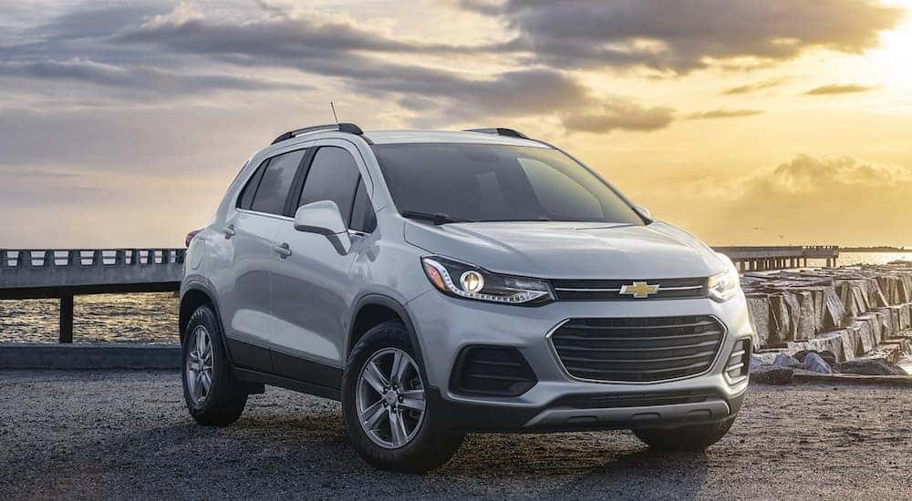 A silver 2021 Chevy Trax for sale is shown parked near an ocean.