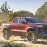 Red 2024 Chevy Colorado Trail Boss driving on a trail