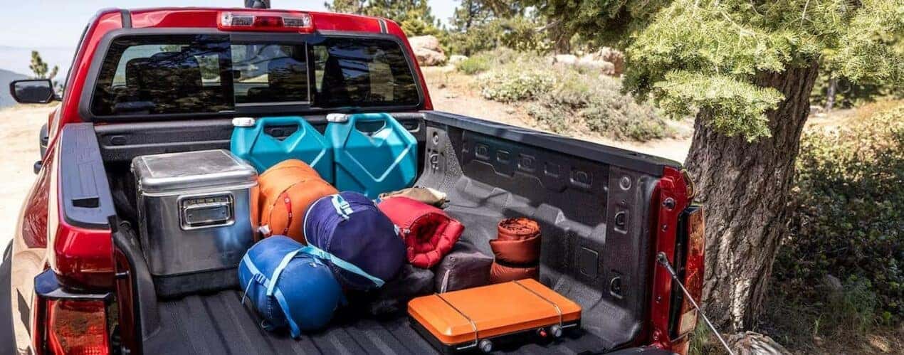 Items are shown stored on the bed of a red 2024 Chevy Colorado.
