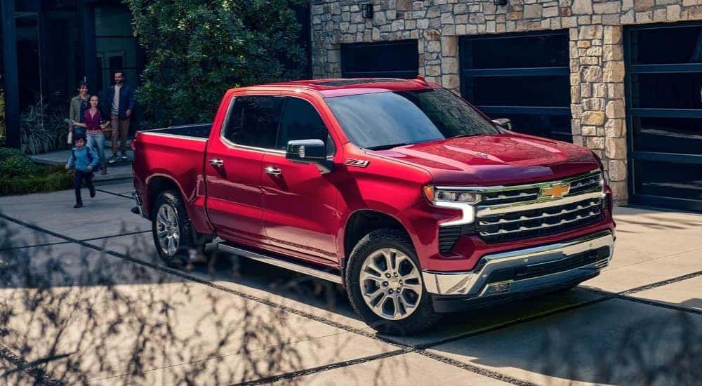 A red 2024 Chevy Silverado 1500 Z71 is shown parked near a family.