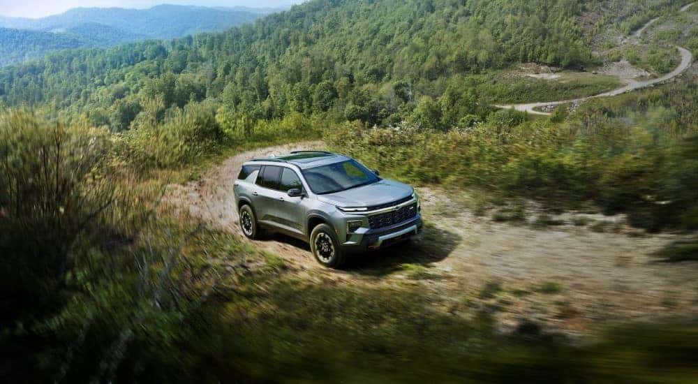 A grey 2024 Chevy Traverse Z71 driving on a mountain trail.