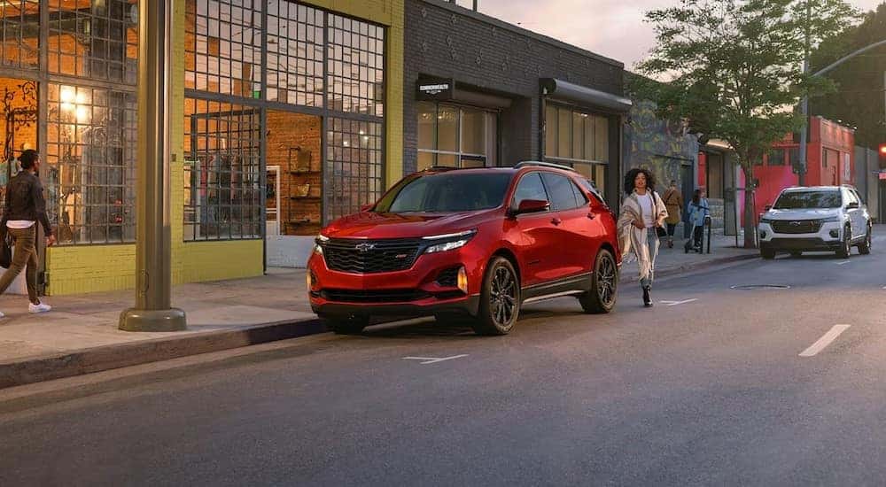 A red 2024 Chevy Equinox RS is shown parked near a boutique.