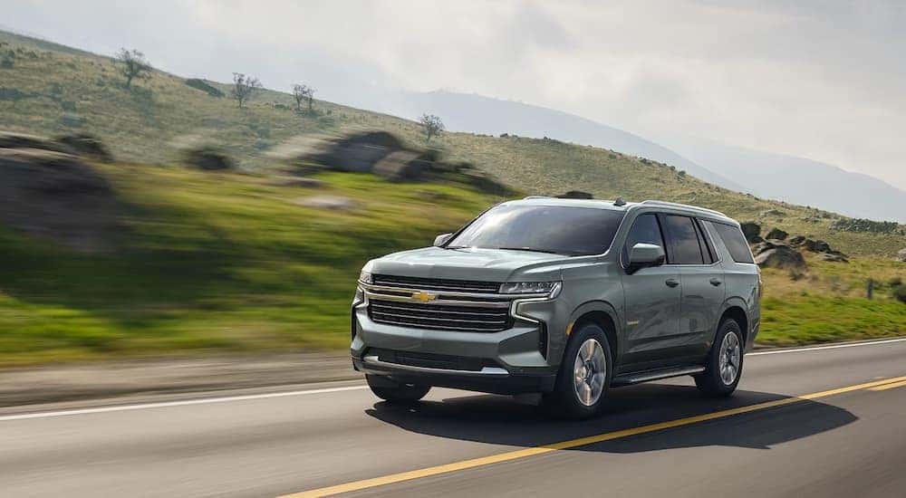 A silver 2024 Chevy Tahoe LT driving on an open road.
