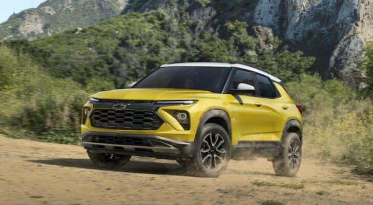 A yellow 2024 Chevy Trailblazer ACTIV is shown driving off-road after viewing a Chevy Trailblazer for sale in Albany.