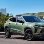 A green 2024 Chevy Trax ACTIV is shown parked near several people.