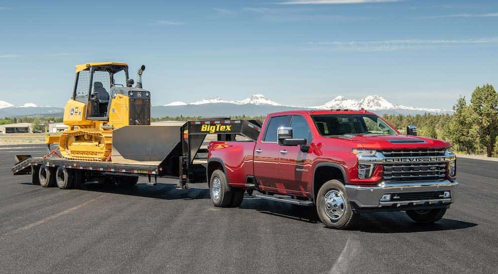 A red 2021 Chevy Silverado 3500 HD is shown parked while towing a Big Tex trailer.