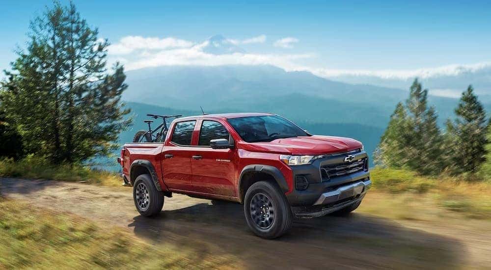 A red 2024 Chevy Colorado Trail Boss is shown driving off-road.