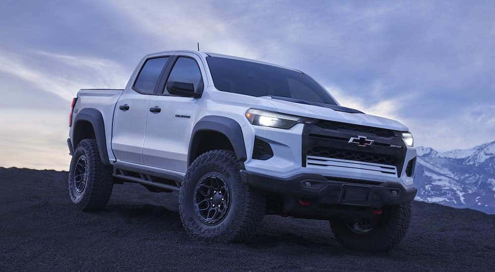 A white 2024 Chevy Colorado driving off-road down a hill and angled right.