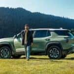 A green 2025 Chevy Equinox ACTIV is shown parked on grass near a family.