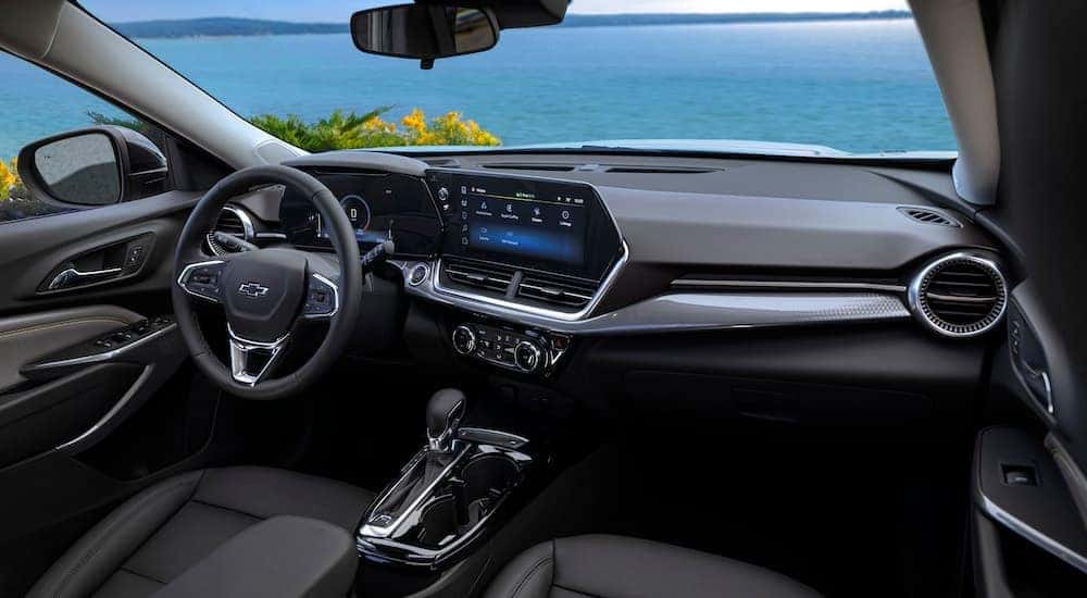 The black interior of a 2024 Chevy Trax ACTIV is shown from the passenger seat.