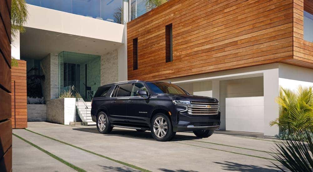 A grey 2022 Chevy Suburban is shown from the front at an angle after leaving a dealer that has a used Chevy for sale.