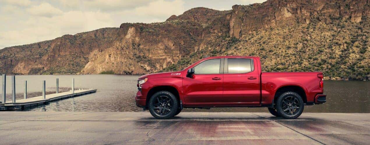 A red 2025 Chevy Silverado 1500 Z71 is shown parked near a lake.