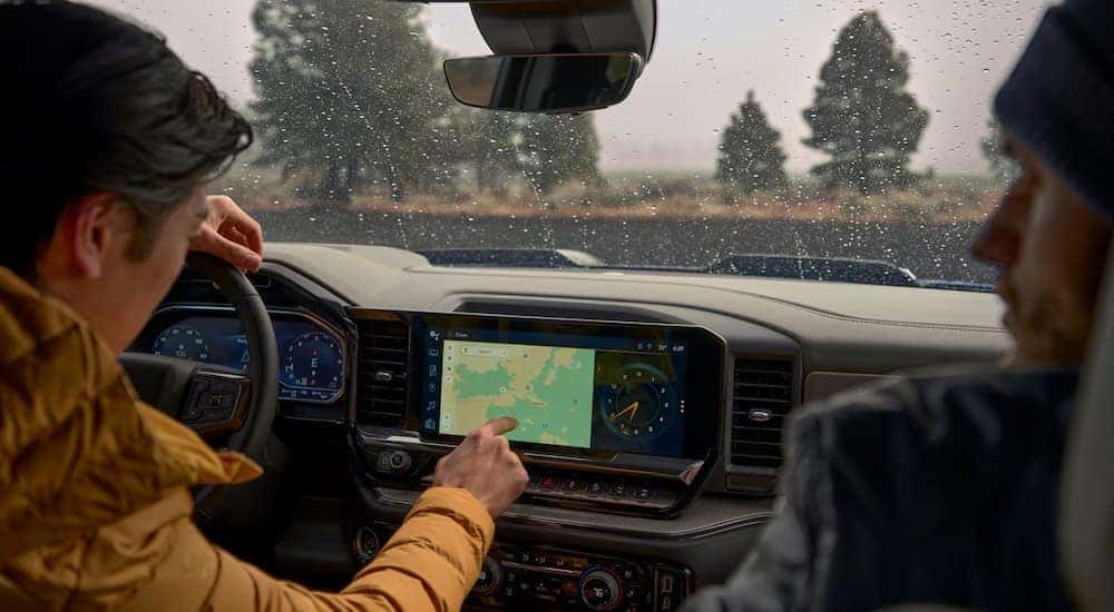 Interior view of two people sitting in the front seats of a 2025 Chevy Silverado 1500.