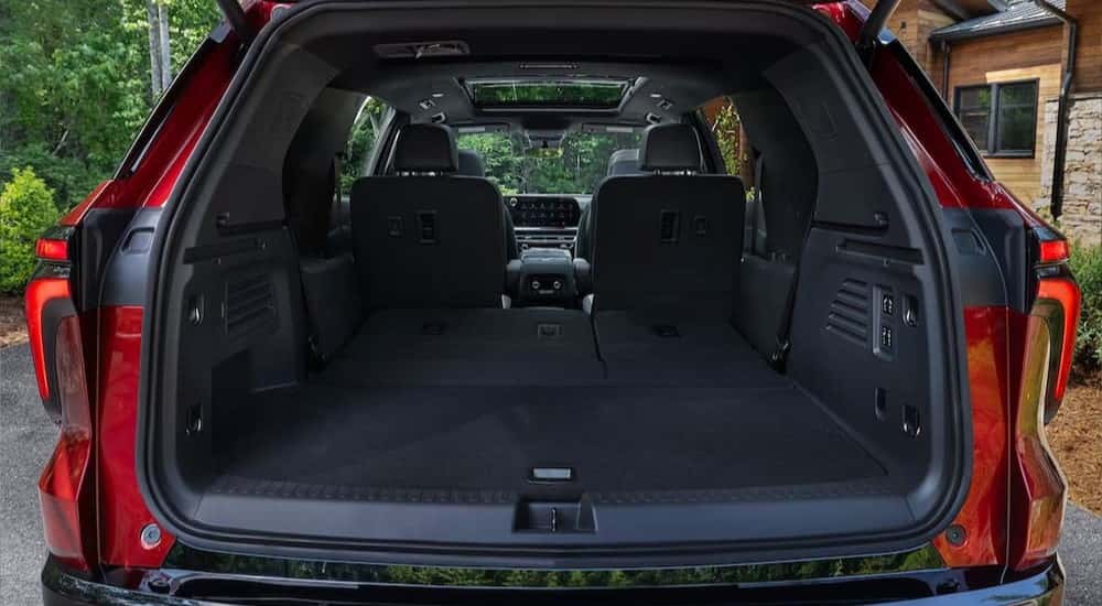 The rear cargo area is shown in a red 2024 Chevy Traverse RS.