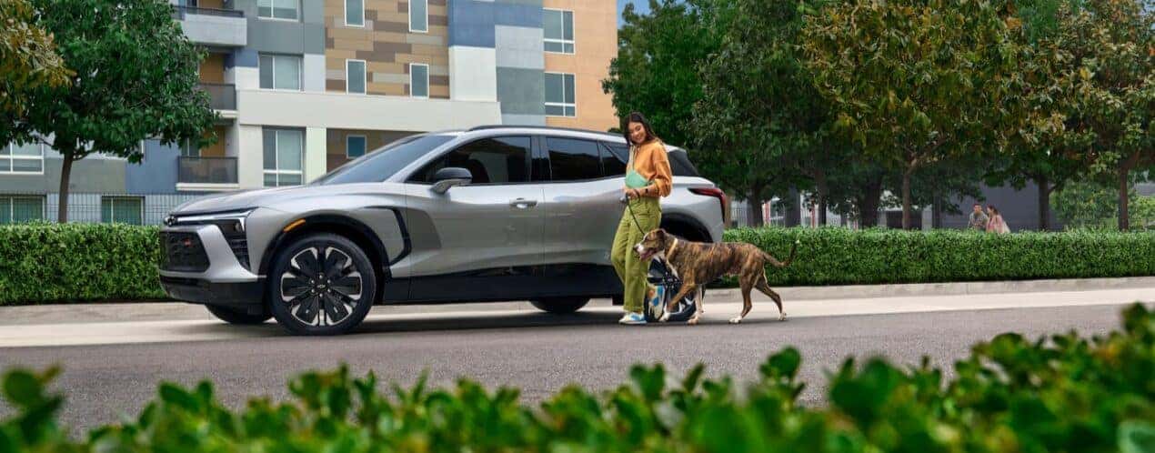 A silver 2025 Chevy Blazer EV RS is shown parked near a dog.