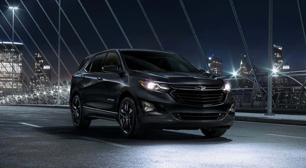 A black 2020 Chevy Equinox Midnight Edition is shown driving on a bridge.