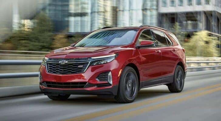 A red 2023 Chevy Equinox RS is shown driving on a bridge after viewing a used Chevy Equinox for sale near Colonie.