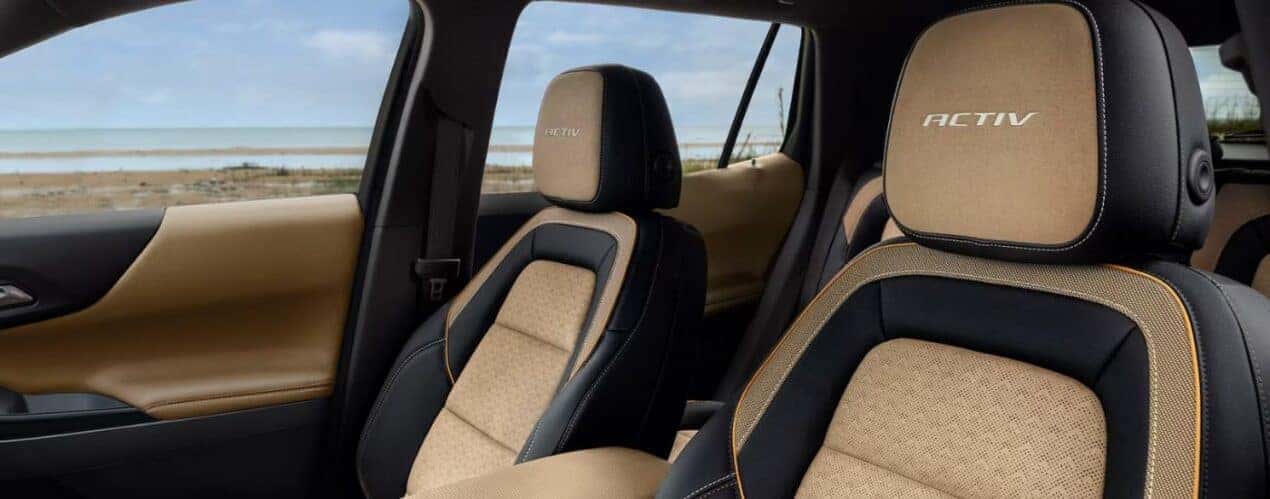 The tan and black upholstered front seats in a 2025 Chevy Equinox ACTIV.