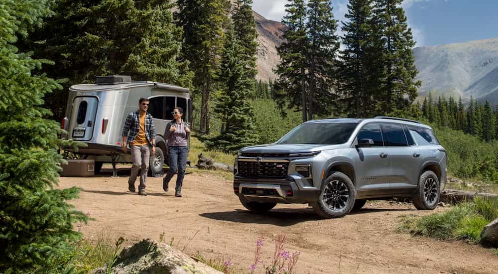 A grey 2025 Chevy Traverse Z71 parked off-road by a camper and angled right.