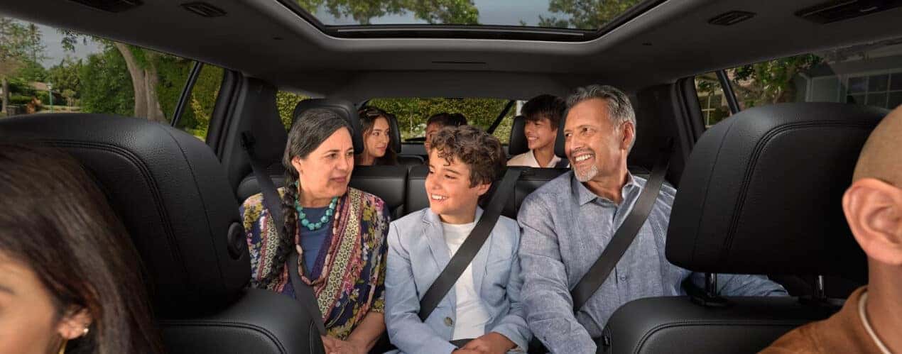 A smiling family is shown in a 2025 Chevy Traverse.