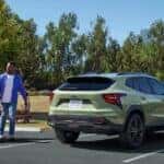 Rear view of a green 2025 Chevy Trax ACTIV parked on a parking lot.