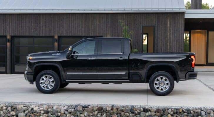 A black 2025 Chevy Silverado 2500HD High Country for sale near Colonie is parked in a driveway.