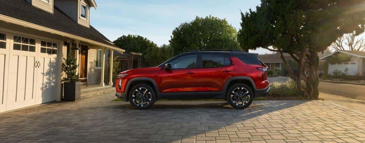 A red 2025 Chevy Equinox RS is parked on a driveway.